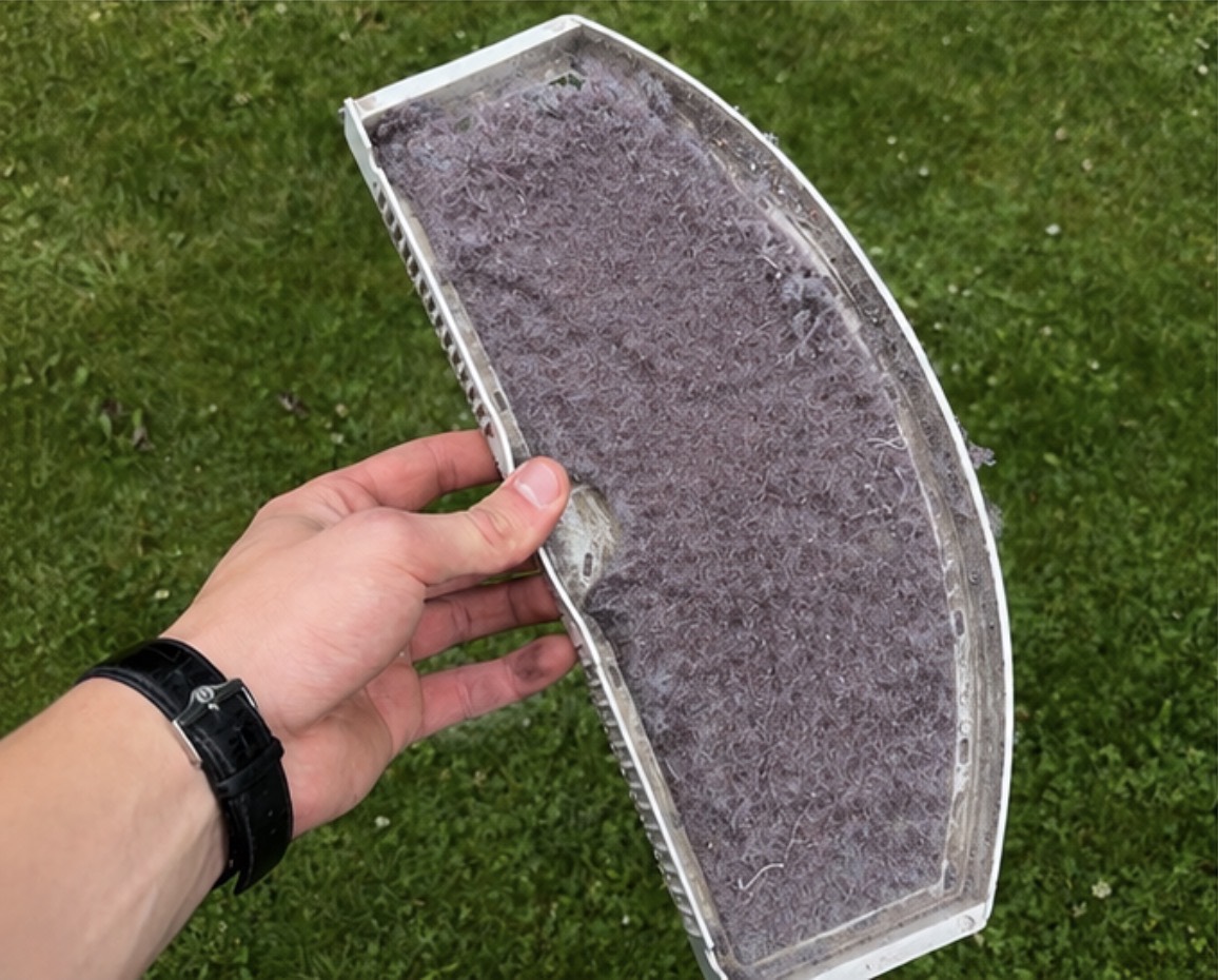 Dryer lint screen with lint buildup before cleaning